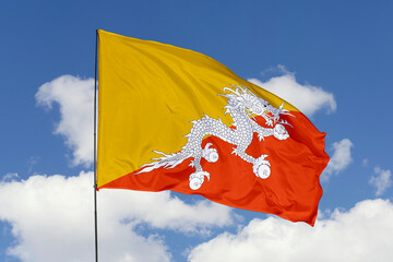 Bhutan flag isolated on the blue sky background. close up waving flag of Bhutan. flag symbols of Bhutan. Concept of Bhutan.