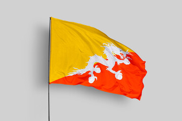 Bhutan flag isolated on the blue sky background. close up waving flag of Bhutan. flag symbols of Bhutan. Concept of Bhutan.