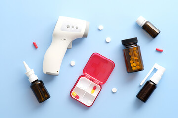 Flu treatments. Nasal spray, amber glass bottle with pills, cough spray, digital thermometer on...