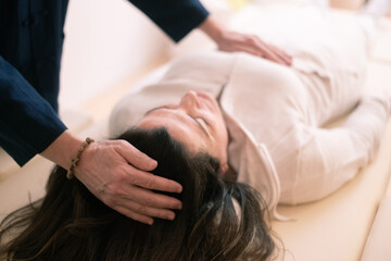 Fototapeta na wymiar Therapist man doing Holistic therapy Reiki to a woman. Energy treatment with the heat of the palm hands. Japanese energy healing. Wellness, health, relax, well-being and alternative medicine concept.