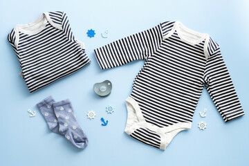 Marine style kids outfit on pastel blue backrgrouns. Set of striped bodysuit, shirst, socks. Flat...