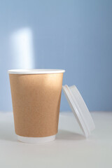 empty paper cup to go against light blue background
