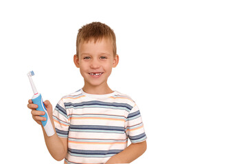 Happy boy child brushes teeth with an electric brush. The milk tooth fell out. New teeth.