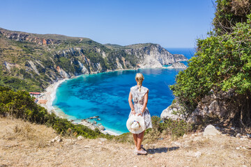 A tourist woman enjoying beautiful Petani beach on Kefalonia Ionian island, Greece, during her summer vacation holiday