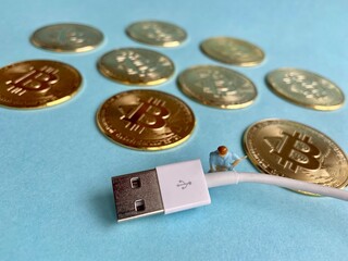 Bitcoin crypto currency concept with energy and electricity use with USB charger symbolising electricity