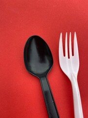 plastic single use disposable cutlery fork and spoon on bright background with copy space 