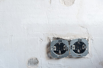 open electrical outlets on a grungy gray wall