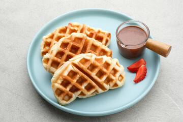 Croissant Waffle or Croffle with chocolate and strawberry topping on grey background. Selective focus image and close up.
