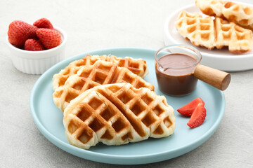 Croissant Waffle or Croffle with chocolate and strawberry topping on grey background. Selective focus image and close up.
