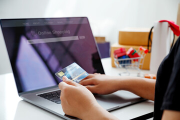 Woman hands holding credit card and using a laptop.Ideas about online shopping addiction.Online shopping concept.Black Friday.