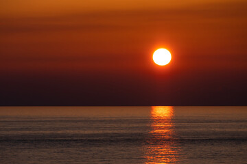 bright sun during a sea sunset. orange color in the sky. the sun is above the sea surface