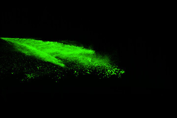 The movement of abstract dust explosion frozen green on black background. Stop the movement of powdered green on black background. Explosive powder green on black background.