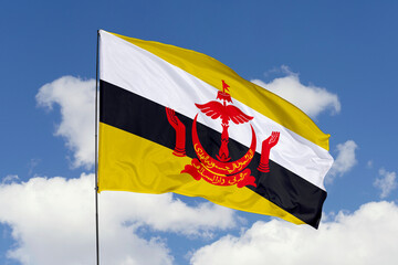 Brunei flag isolated on the blue sky background. close up waving flag of Brunei. flag symbols of Brunei. Concept of Brunei.