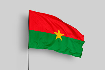 Burkina Faso flag isolated on the blue sky background. close up waving flag of Burkina Faso. flag symbols of Burkina Faso. Concept of Burkina Faso.