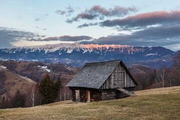 Wooden cottage in a mountain winter landscape.