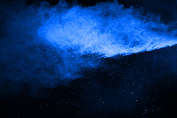 abstract blue powder splatted background,Freeze motion of color powder exploding/throwing color powder,color glitter texture on black background.