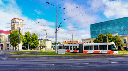 Modern tram passing by a square in the city of Tallinn Estonia.