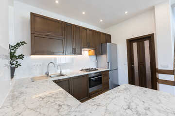 Modern wooden kitchen in scandinavian interior with cooking appliances. Real image