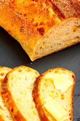 Buttered slices of sourdough bread laid on a slate serving platter