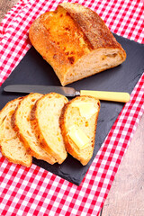Buttered slices of sourdough bread laid on a slate serving platter