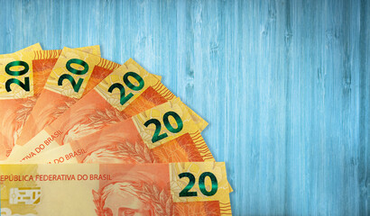 Twenty Brazilian reais banknote and blue wooden background.