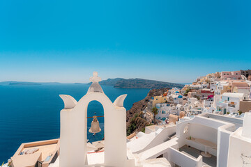 Fototapeta na wymiar Blue dome and white Church bell tower in the village of Oia in Santorini, Greece