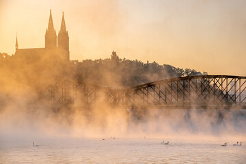 Amazing foggy view of Old Vysehrad Basilica of saint Peter and Pavel, Sunlight over historical...