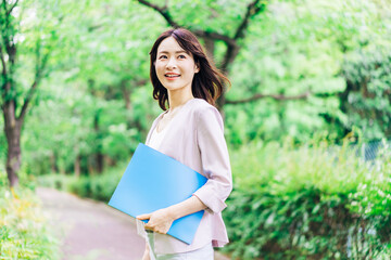 Fototapeta premium 書類を持って歩く若いビジネスウーマン