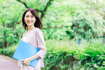 書類を持って歩く若いビジネスウーマン