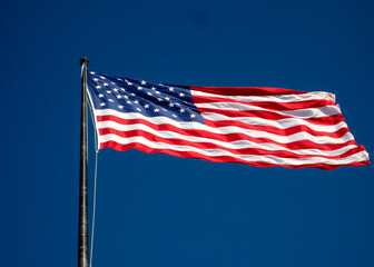 American flag, the Stars and Stripes, isolated against a deep blue sky