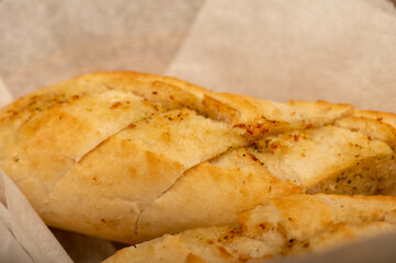 Baguette with garlic paste cut into pieces, close-up, selective focus.