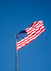 American flag, the Stars and Stripes, isolated against a deep blue sky