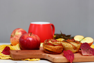 Cup of black tea and apple cupcakes. Close up photo of beautiful dessert tart. Rose shaped Apple Pies on a table. 