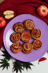 Obraz na płótnie Canvas Apple Rose Cupcakes top view photo. Freshly baked sweet apple pies on a table. Autumn dessert ideas. 