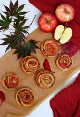 Small apple cupcakes top view photo. Rose shaped tarts with red apples, honey and cinnamon. Autumn food ideas. 