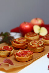 Obraz na płótnie Canvas Small apple cupcakes top view photo. Rose shaped tarts with red apples, honey and cinnamon. Autumn food ideas. 
