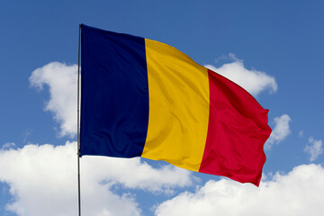 Chad flag isolated on the blue sky background. close up waving flag of Chad. flag symbols of Chad. Concept of Chad.