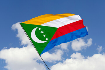 Comoros flag isolated on the blue sky background. close up waving flag of Comoros. flag symbols of Comoros. Concept of Comoros.