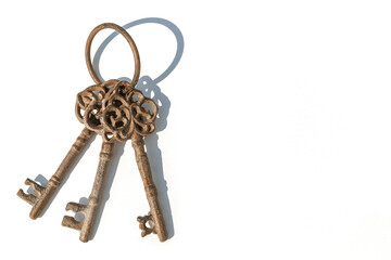 Three old rusty brown keys on a white background