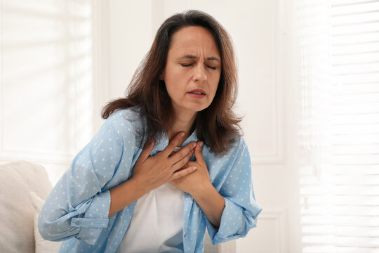 Mature woman suffering from breathing problem at home