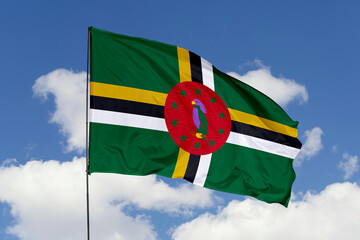 Dominica flag isolated on the blue sky background. close up waving flag of Dominica. flag symbols of Dominica. Concept of Dominica.