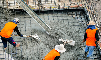 A construction worker pouring a wet concret - obrazy, fototapety, plakaty