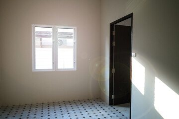 white wall in new house. ceramic in living room. big square windows clear orange sun light background on wall.