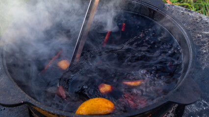 Boilers with hot mulled wine. Mulled wine is cooked in an old boiler on the street. Cooking on an...
