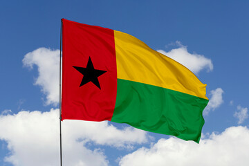 Guinea Bissau flag isolated on the blue sky background. close up waving flag of Guinea Bissau. flag symbols of Guinea Bissau. Concept of Guinea Bissau.