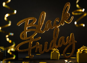 Golden inscription Black Friday on dark background with gift present boxes
