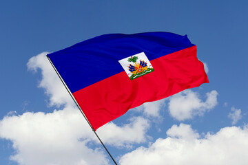 Haiti flag isolated on the blue sky background. close up waving flag of Haiti. flag symbols of Haiti. Concept of Haiti.