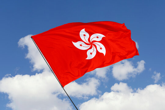 Hong Kong flag isolated on the blue sky background. close up waving flag of Hong Kong. flag symbols of Hong Kong. Concept of Hong Kong.