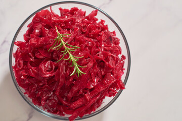 Red cabbage sauerkraut served in a glass bowl. Vegetarian food.