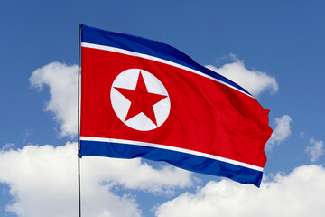 North Korea flag isolated on the blue sky background. close up waving flag of North Korea. flag symbols of North Korea. Concept of North Korea.